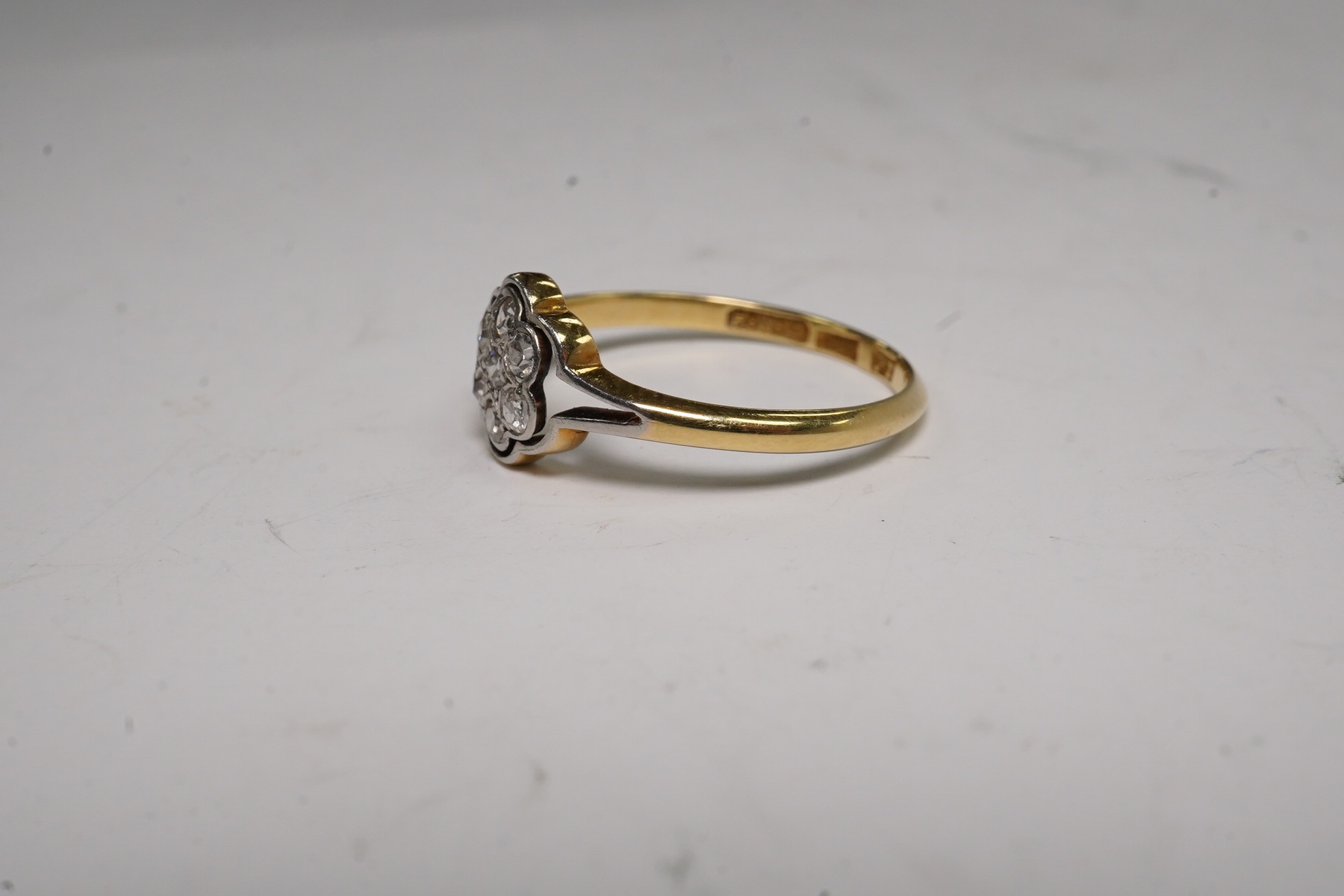 A 1940's 18ct, plat and diamond set flower head cluster ring, size O, gross weight 2.1 grams.